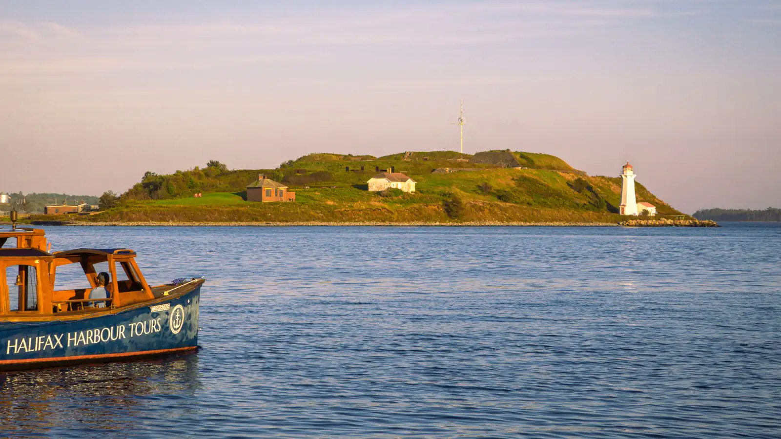 Calm water in Halifax Harbour with Georges Island and its lighthouse in soft evening light